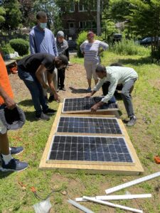 People working on a solar panel outdoors.